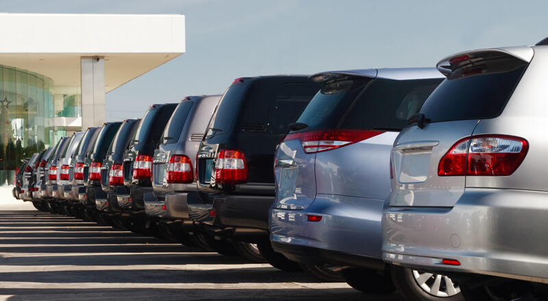 Cars in a dealership lot.