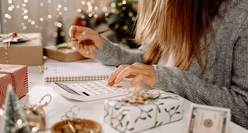Woman doing budget, estimating money balance for Christmas shopping.