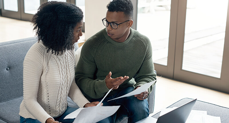 A young couple going over paperwork at home.