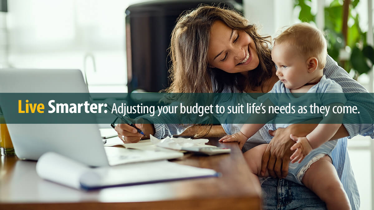 Young happy mother going through home finances and communicating with her baby son.