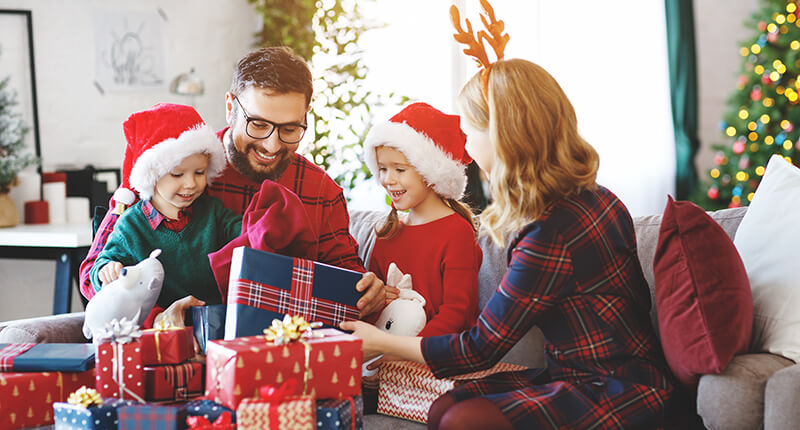Happy family open presents on Christmas morning.