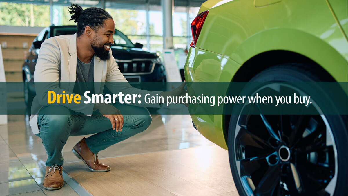 Happy black man looking for a new car in showroom.
