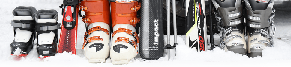 Skis, boots, and poles paid for with vacation financing sit in the snow near a car