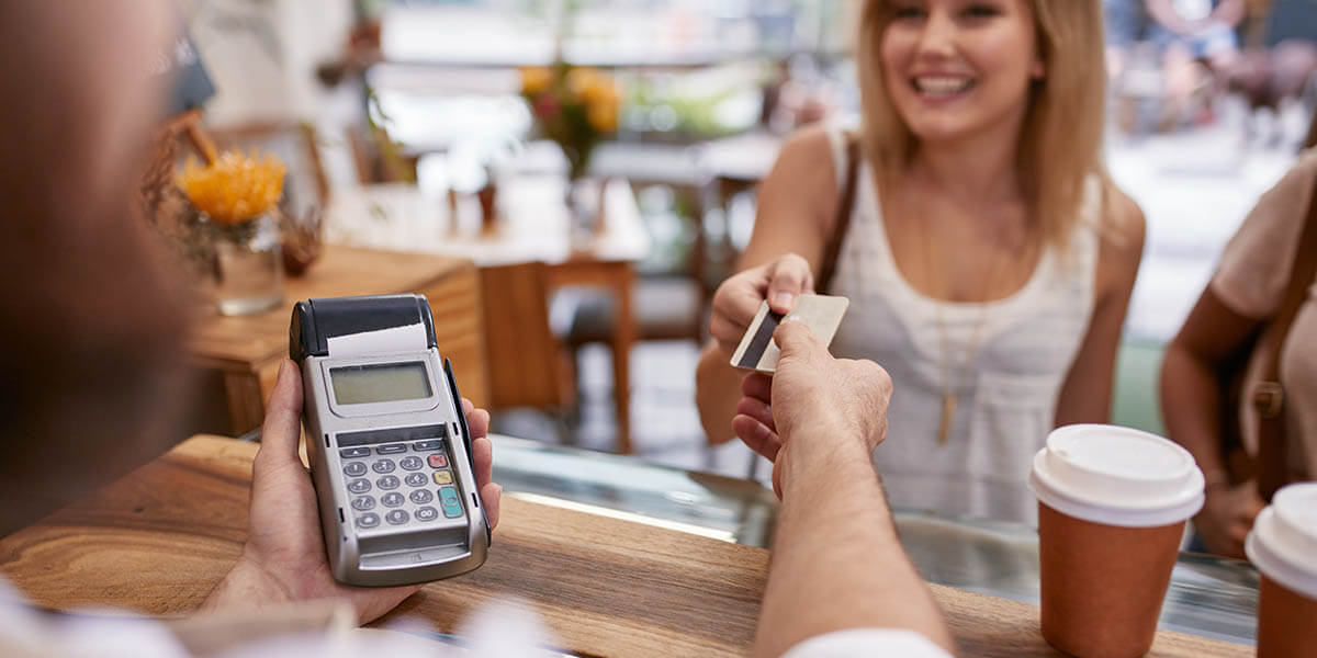 Customer paying for their order with a credit card in a cafe.