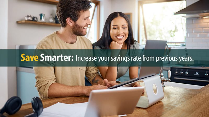 Happy young caucasian man working on laptop while his wife stands next to him looking at the screen