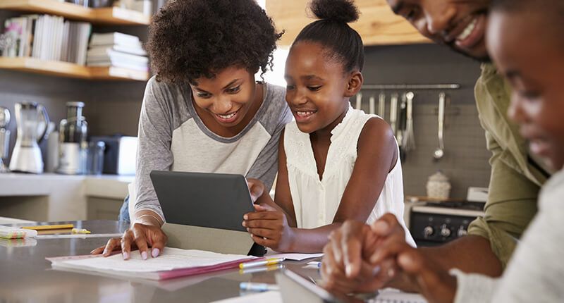 Parents help young children with homework as they prepare for attending college someday