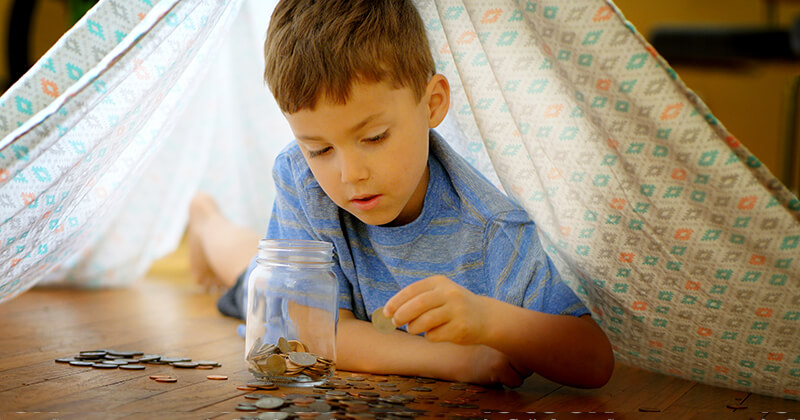 Young boy counting the coins he has saved.