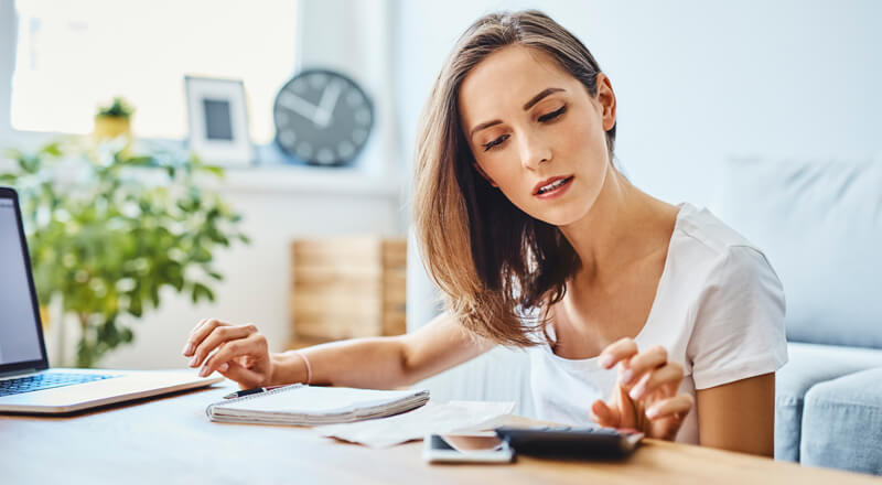 A woman reviews her finances from her home.