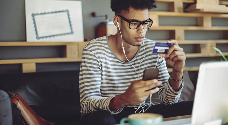 Responsible young man using a credit card.