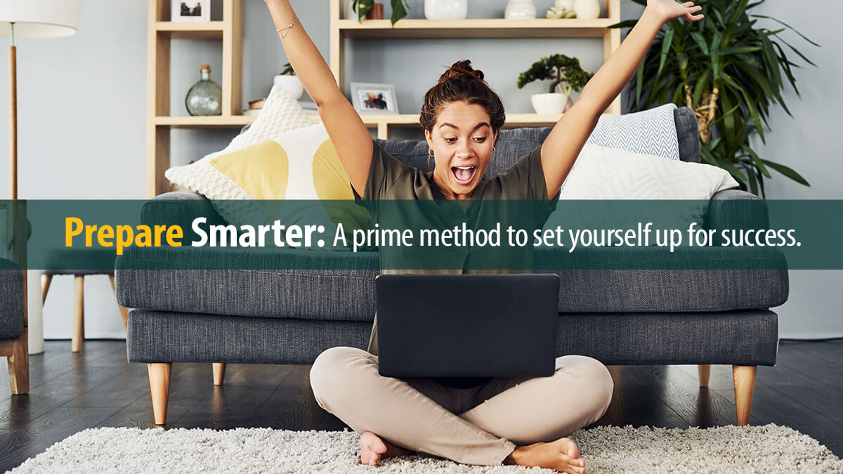 Young woman cheering while using a laptop on the living room floor at home