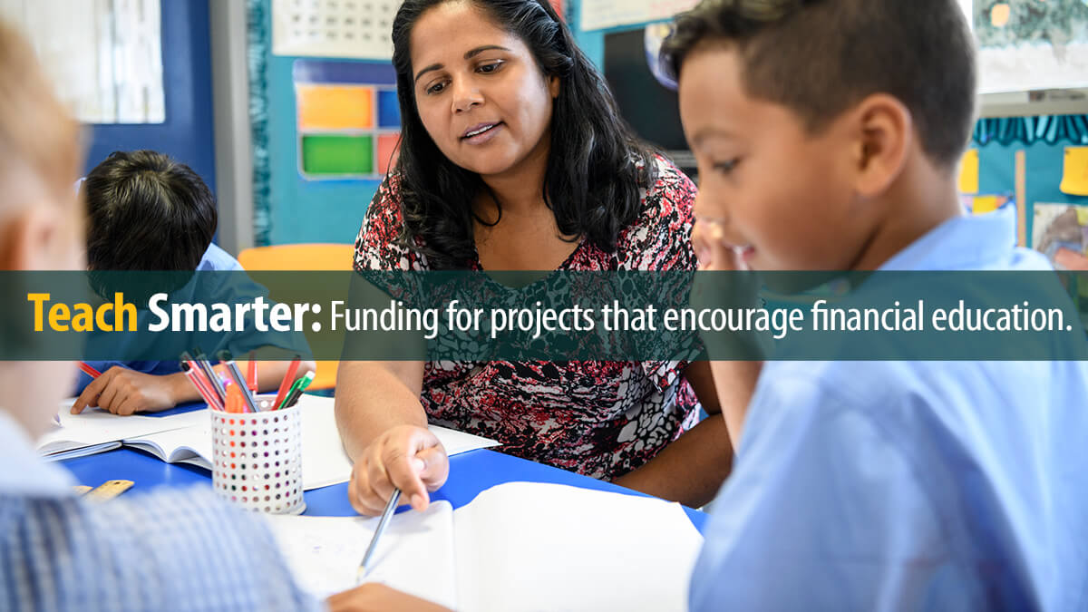 Primary school teacher helping young boy in the classroom