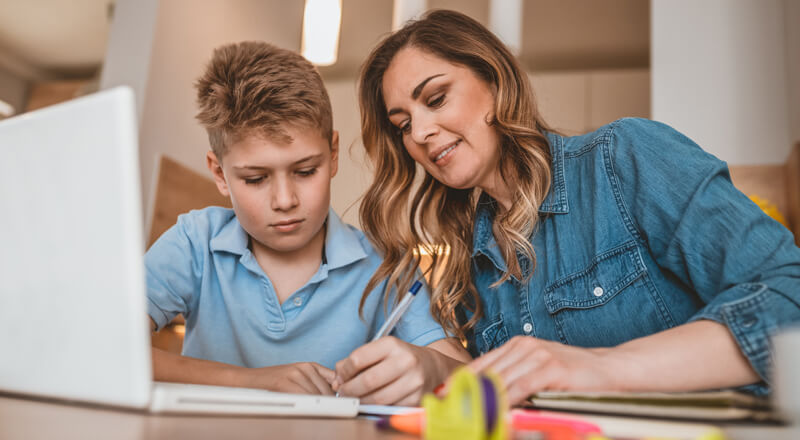 A mother teaching her son from home.