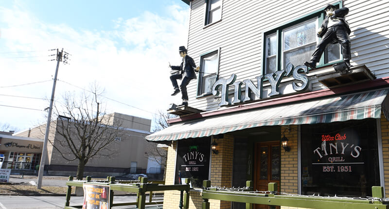 Outside front view of Tiny’s Grill, using First Source Business Services, Players of Utica in background